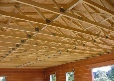 Structure de charpente en bois installée par ECB pour un bâtiment neuf, garantissant solidité et durabilité.