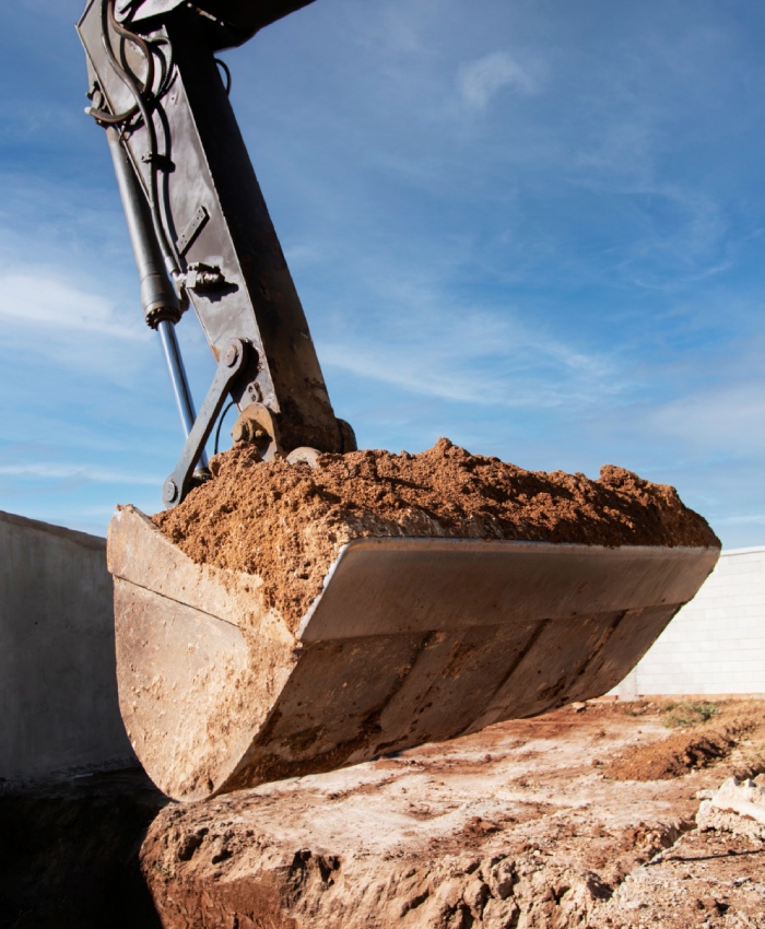 Godet de pelle en pleine excavation Godet de pelle mécanique soulevant de la terre lors d’un chantier de terrassement